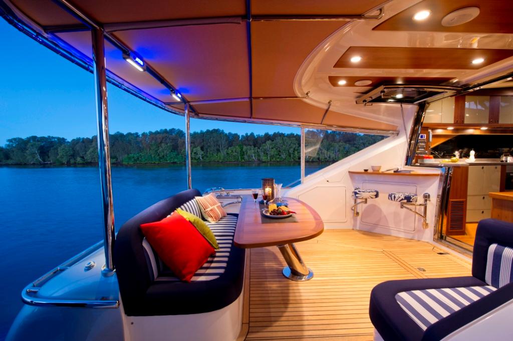 The Belize 54 Sedan cockpit features a rear lounge with storage below, a hi-lo table, and two swivel stools that create a unique bar area © Stephen Milne